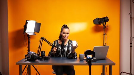 Videographer using editing software to assemble footage into cohesive final result, color correcting it to ensure project meets desired aesthetic, working in creative studio